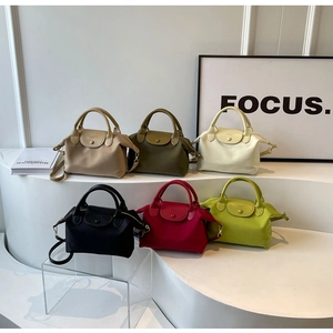 Selection of colorful nylon handbags with leather handles in a modern interior display