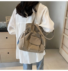 Detail of khaki corduroy tote bag featuring drawstring closure and textured fabric