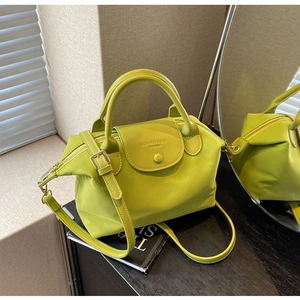 Detail of light green oxford cloth crossbody bag with buckle flap and stylish stitching