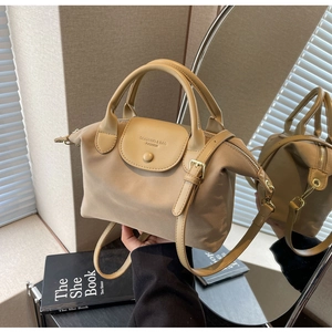 Detail of khaki oxford nylon dumpling bag with leather texture and mirror reflection view