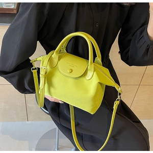 Neon green textured oxford cloth handbag featuring golden hardware and leather straps