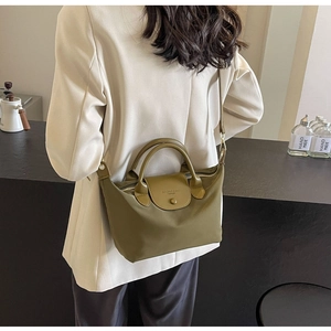 Olive green nylon crossbody bag detail with leather trim and adjustable shoulder strap