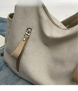 Close-up of beige canvas fabric texture with metal zipper and leather rivet puller detail