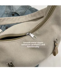 Detailed macro shot of smooth metal zipper head on durable beige canvas shoulder bag