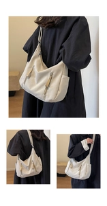 Close-up of beige canvas bag showing multiple functional zipper pockets and large capacity