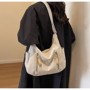 Detail of multi-pocket canvas hobo bag with zip pockets and wide shoulder strap