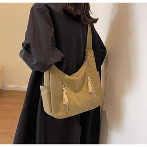Macro detail of mustard canvas hobo bag with vintage metal zippers and leather pullers