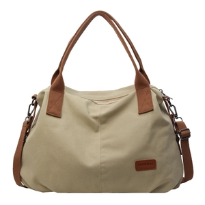 Large beige canvas tote bag with brown handles and adjustable shoulder strap for women