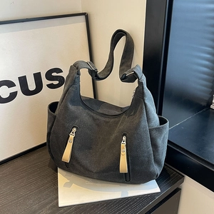 Large capacity dark grey canvas crossbody bag with multi-pocket design on wooden table