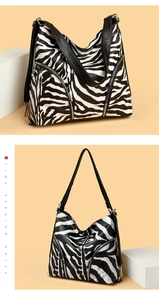 Detail of zebra pattern shoulder bag with black lychee leather handles and silver zippers