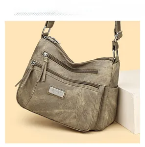 Detail view of large-capacity vintage messenger bag with multiple zipper compartments