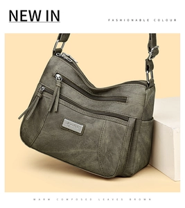 Detail view of multi-pocket crossbody bag in gray-green with durable zip compartments