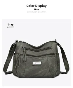 Detailed front view of grey soft leather crossbody bag with multiple zip pockets