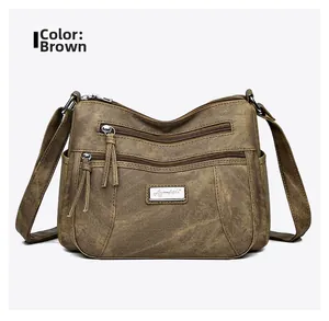 Close-up of yellow vintage PU leather bag with multi-layer zippers and metallic logo detail