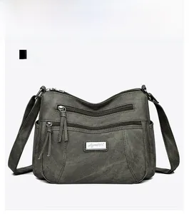 Detailed front view of green canvas crossbody bag featuring multiple zipper pockets