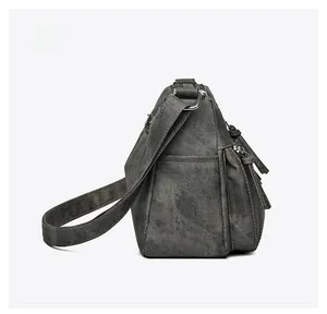 Side view detail of washed canvas messenger bag showing adjustable strap and pockets