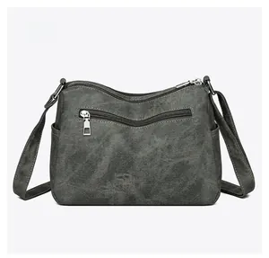 Rear view of grey canvas crossbody bag showing back zipper pocket and side slots