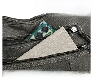 Detail view of durable gray canvas shoulder bag showing front zipper pocket storage