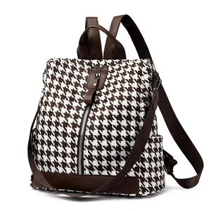 Women's houndstooth backpack with brown leather accents and multi-pocket design