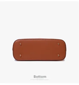 Close-up of tote bag bottom with four protective gold-tone metal feet and pebbled leather