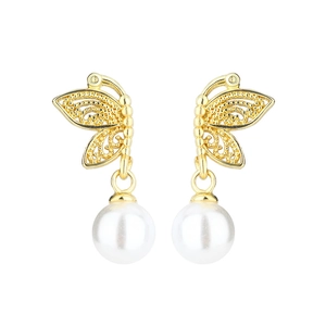 Detail of vintage gold butterfly earrings with white pearls and hollow wing pattern