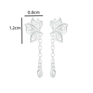 Détail des boucles d'oreilles papillon argentées avec pompons et dimensions de 0.8cm sur 1.2cm