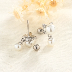 Close-up of cat-shaped S925 silver earring with freshwater pearls and sparkling zircon details