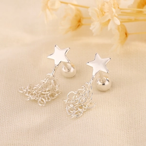 Détail macro de boucles d'oreilles étoile argent avec franges de chaîne et fermoir boule