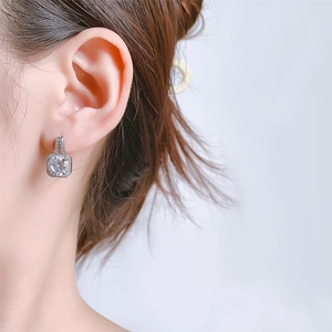 Close-up of elegant square halo cubic zirconia earrings worn on a female ear