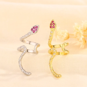 Detailed view of silver and gold snake ear cuffs with red and white zircon accents