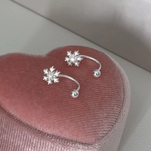 Elegante Schneeflocken-Ohrringe mit Kristall auf einer rosa Herz-Samt-Schmuckschatulle
