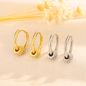 Detail of S925 sterling silver hoop earrings with gold plating and sparkling zircon stones