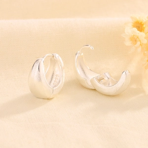 Macro shot of S999 silver U-shaped earrings with a brushed matte finish and secure clasp