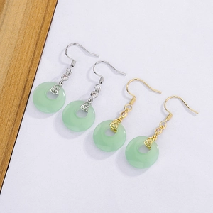 Detailed view of Chinese style jade-colored earrings with clouds pattern in gold and silver