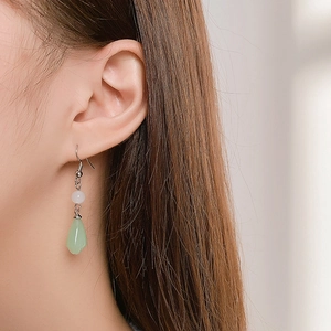 Close-up of elegant green teardrop tassel earring on model in vintage Chinese style