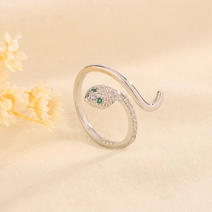 Bague serpent argentée avec micro-pavage de zircones blancs et yeux en pierres vertes