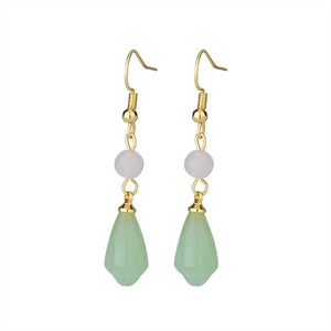Detail view of long tassel earrings with gold hooks and green magnolia flower buds