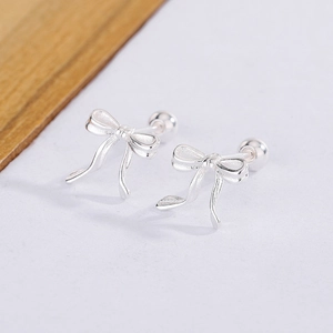 Détail de boucles d'oreilles nœud argenté avec fini mat et fermoir à vis sécurisé