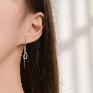 Elegant silver tassel earrings with hollow water drop pendant and pavé crystals on a model