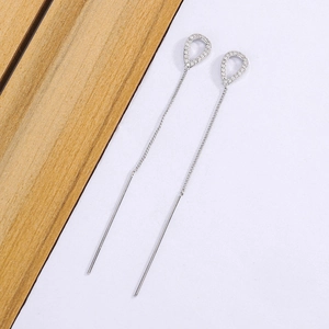 Long tassel water drop earrings in silver with cubic zirconia on wooden background