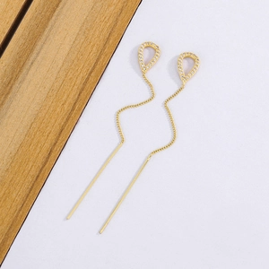 Long tassel drop earrings featuring gold wavy lines and shimmering zircon teardrop accents