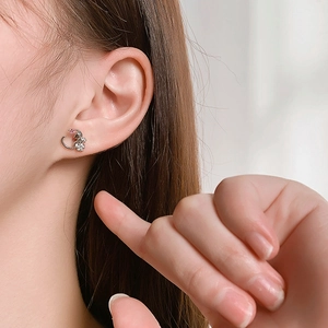 Close-up of cat on moon silver earring with pink zircon on a model's ear