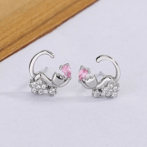 Macro shot of silver cat earrings with pink drop-shaped zircon and white crystal accents