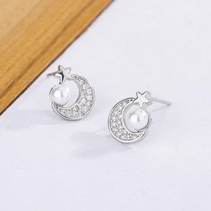 Detailed view of silver moon and star earrings with pavé zircons and creamy pearls