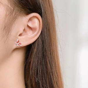 Elegant butterfly enamel ear stud with red gradient and silver edge worn by a model
