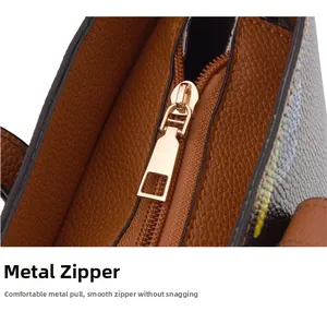 Macro view of gold metal zipper and pebble grain leather on brown tote bag