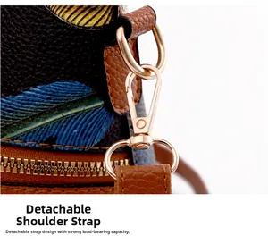 Detail of gold metal hooks and detachable strap on brown litchi grain leather tote bag