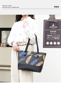Fashionable black leather tote bag with colorful feather prints worn by a model