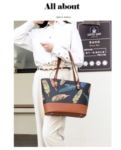 Detail view of large tote bag with colorful feather print and brown leather handles