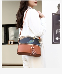 Detail of retro tote bag with brown lychee grain leather and feather print accents